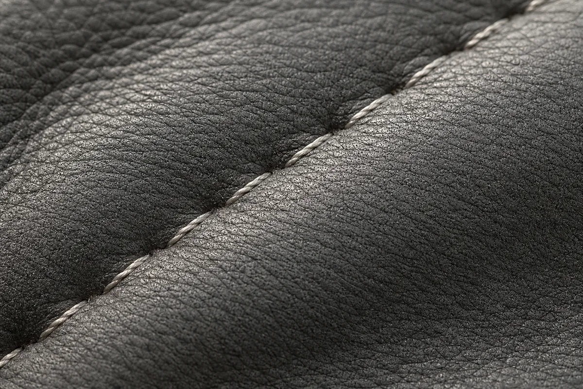 Grain du cuir gris d’une banquette arrière éclairé en lumière rasante
