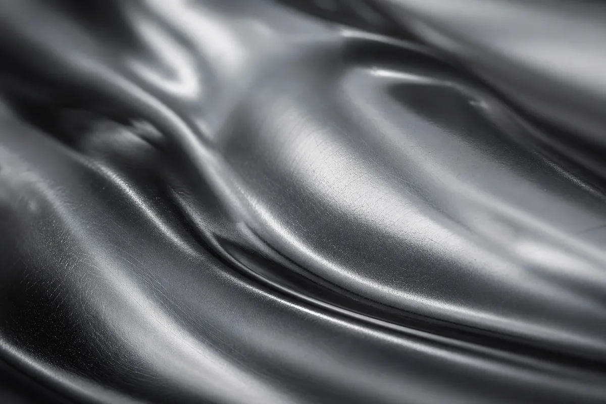 Grande surface de tôle laquée gris anthracite légèrement froissée, reflets diffus d’un ciel couvert