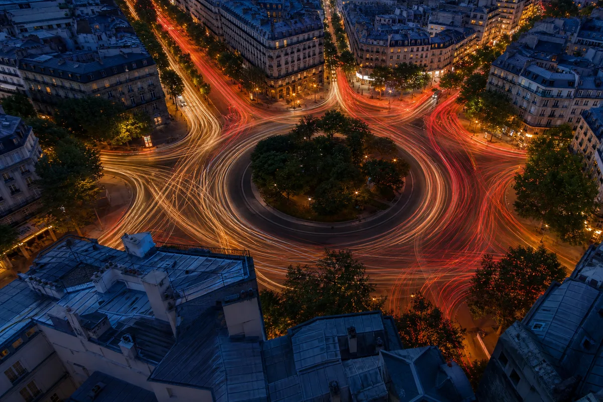 Vue plongeante sur un carrefour urbain au crépuscule, longue exposition et traînées lumineuses